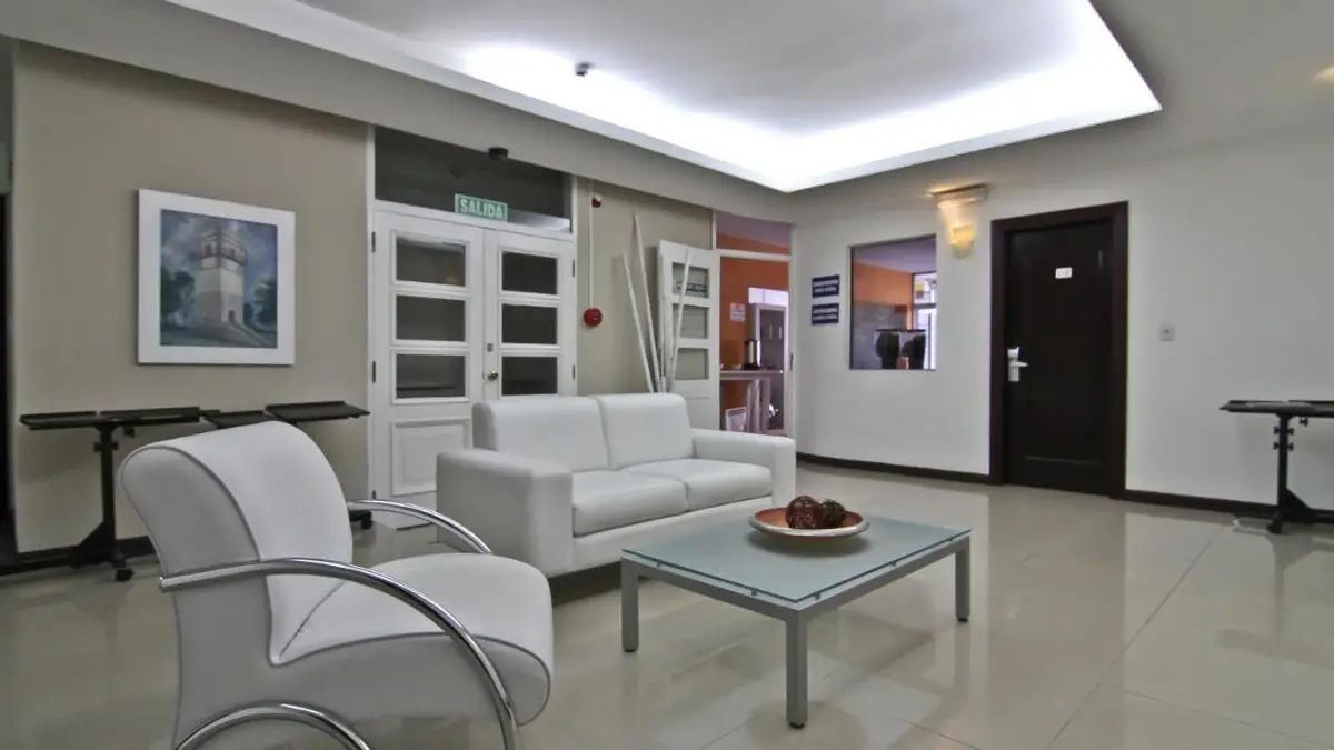 Sala de estar con sillones blancos del De la Plaza Hotel